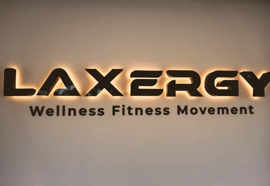 Logo retroiluminado de Laxergy con la leyenda Wellness Fitness Movement en la recepción